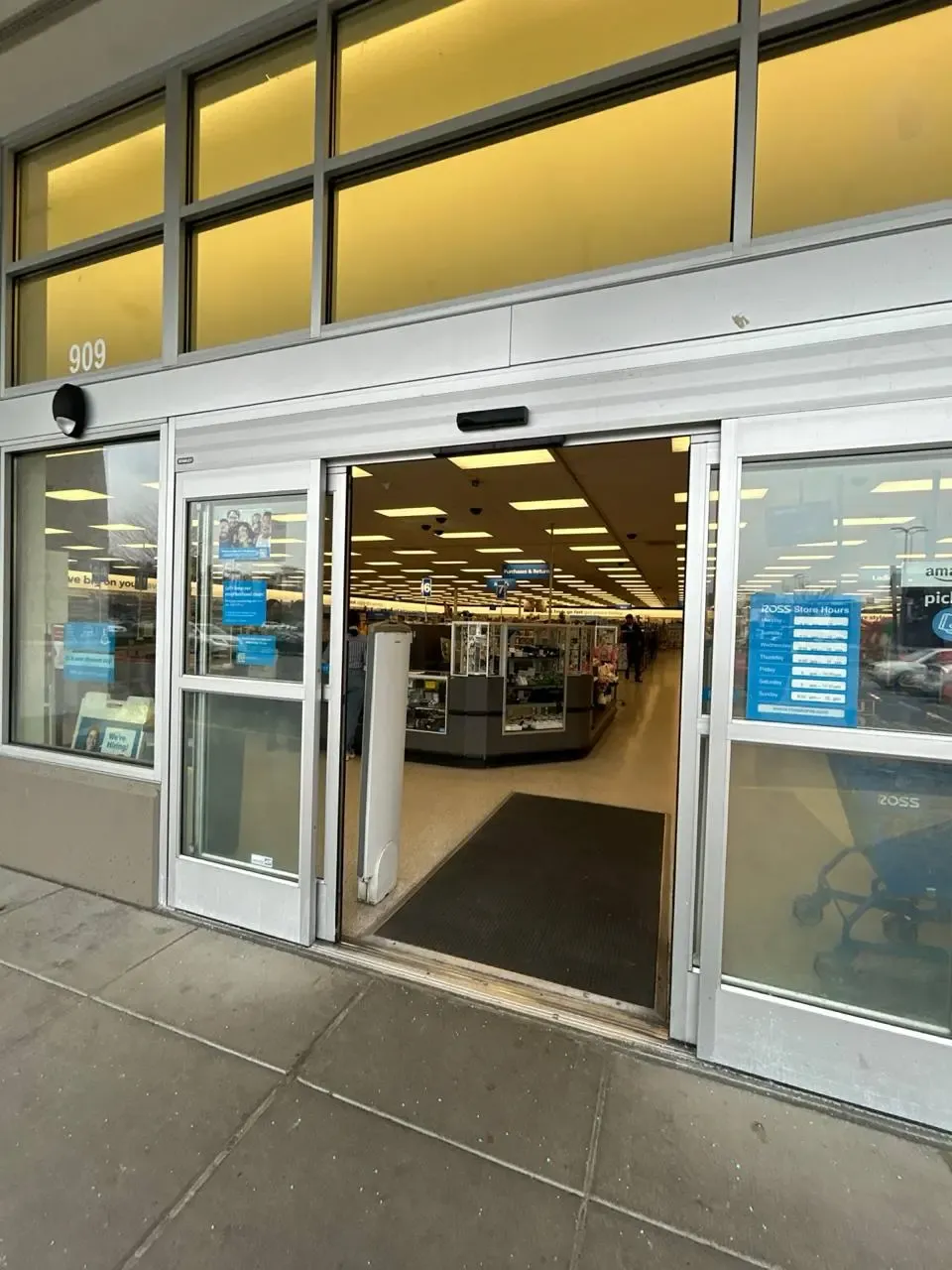 An open automatic sliding glass entrance to a retail store.