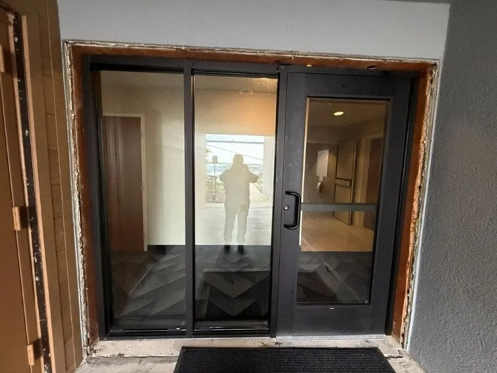Commercial glass entrance installation with unfinished surrounding trim