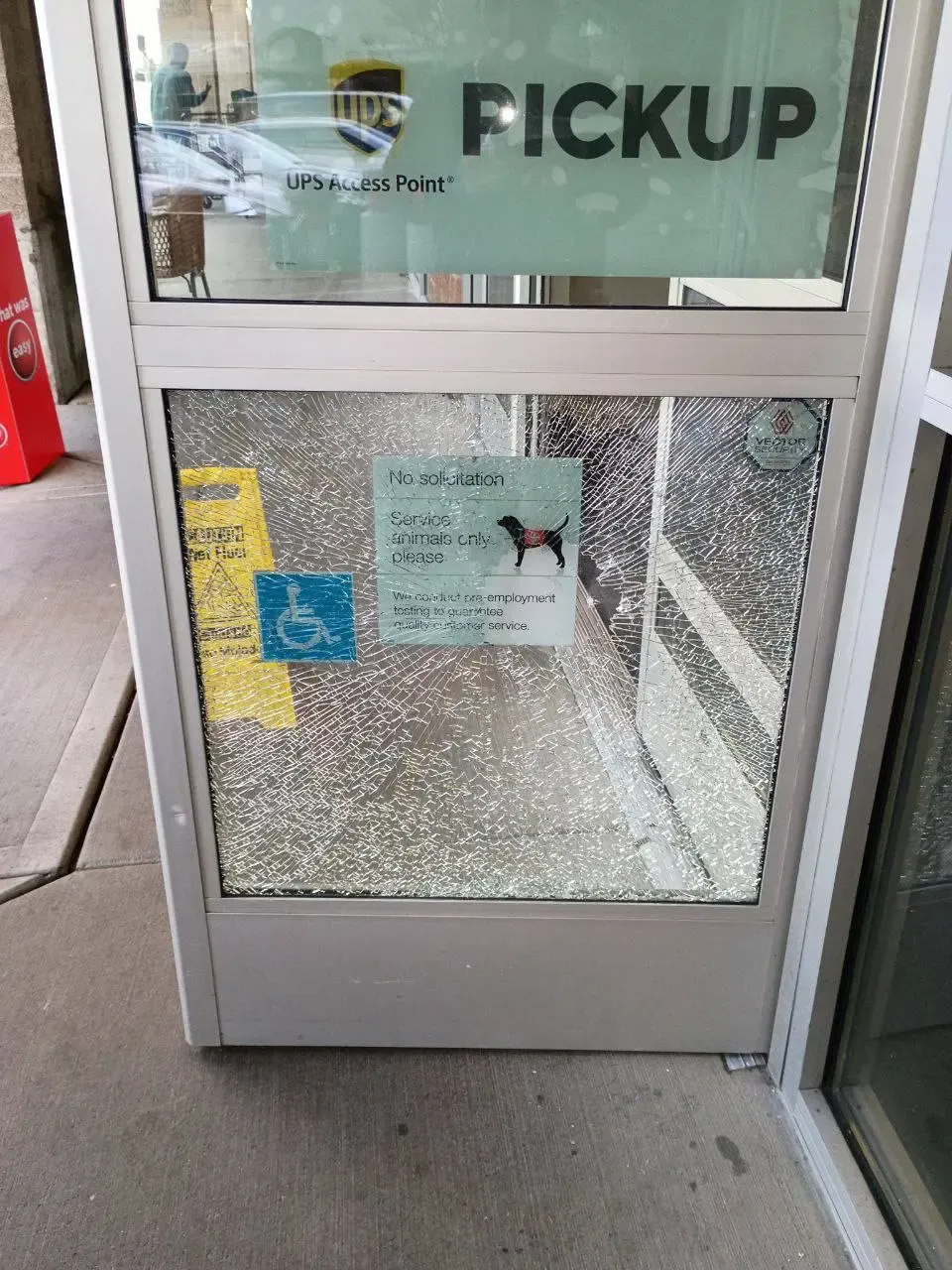 Shattered lower glass panel in a commercial entrance door.
