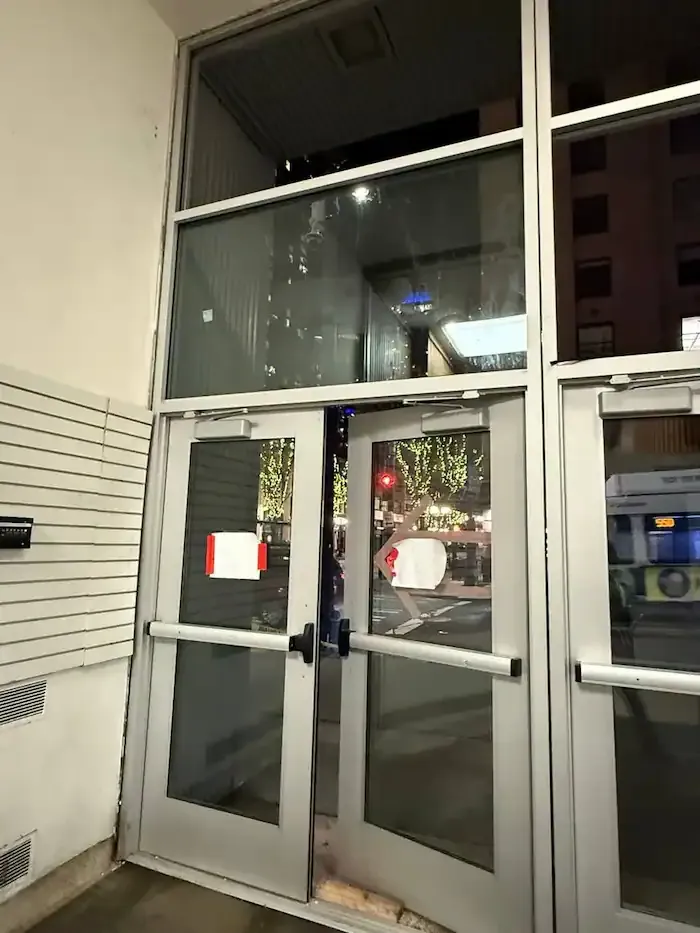 Paired commercial glass entrance doors beneath tall transom windows