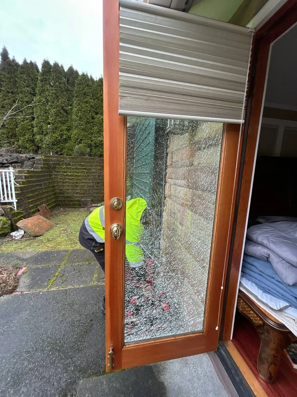Shattered glass in an open wood-framed residential door.