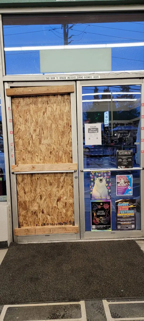 storefront door with broken glass boardup