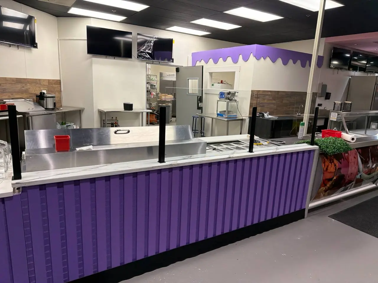 Counter partition with black posts and clear glass panels from the front