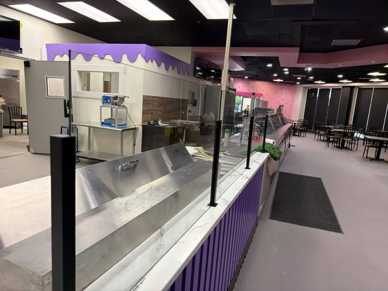 Side view of black posts and clear partition glass along a service counter